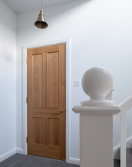 Wooden, shaker style, panelled internal doors with brass door furniture and white painted walls. Part of a house renovation in London UK.