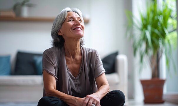 Senior lonely woman talk to voice assistant at home happily. Old woman using smart gadgets at home, talking to smart speaker and listening to the music. Smart AI speaker concept.