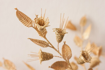 The bouquet flowers is made of straw on a white background. Straw weaving. Small depth of field