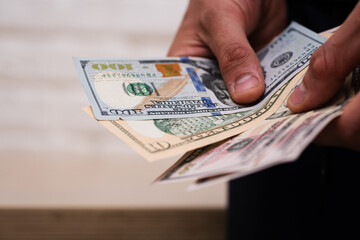 Close-Up of Young Man Holding US Dollars in Hands