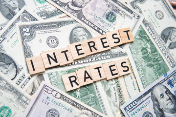 The inscription interest rates on the background of American dollars. Concept showing interest rate cuts in the United States