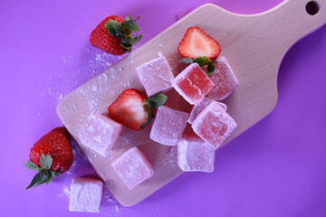 Turkish delight with fresh strawberries and fruit tea in a glass glass