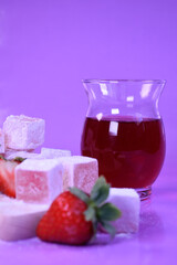 Turkish delight with fresh strawberries and fruit tea in a glass glass