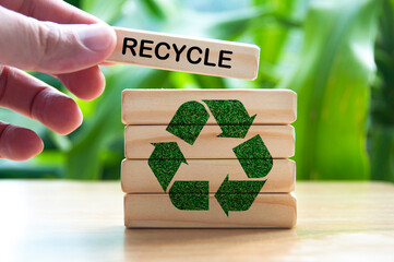 Hand placing wooden block with text recycle. Recycle concept with recycle symbol