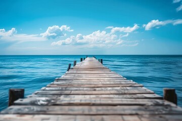 Fototapeta premium Tranquil Wooden Pier Extending into Calm Blue Ocean offers a peaceful seaside retreat for relaxation and meditation