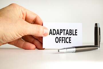 Adaptable office symbol. Concept words Adaptable office on beautiful white paper. Beautiful white background. Businessman hand. Business Adaptable office concept. Copy space.