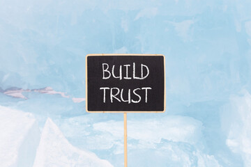 Build trust symbol. Concept words Build trust on beautiful yellow black blackboard. Beautiful blue...