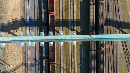 Obraz premium Drone photography of railway, wagons and pedestrian bridge during spring day