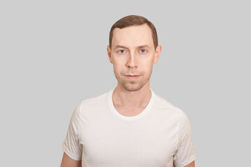 Fototapeta premium Serious european man. Beauty cosmetology portrait. Calm health relax concept. Opened eyes. Male person. Dream about travel. Clean skin procedure. Handsome adult. Grey background