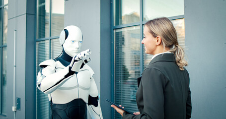 Businesswoman works with artificial intelligence machine in business center. Beautiful satisfied...