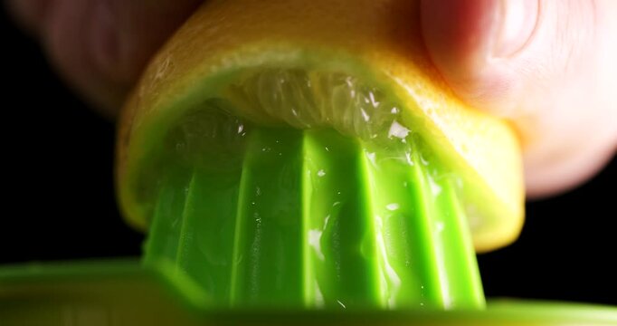 Squeezing the juice of half a lemon by hand.