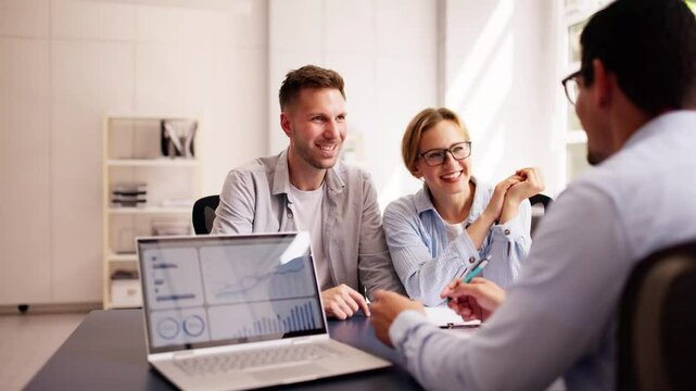 Young couple discussing their financial future with a Hispanic financial planner
