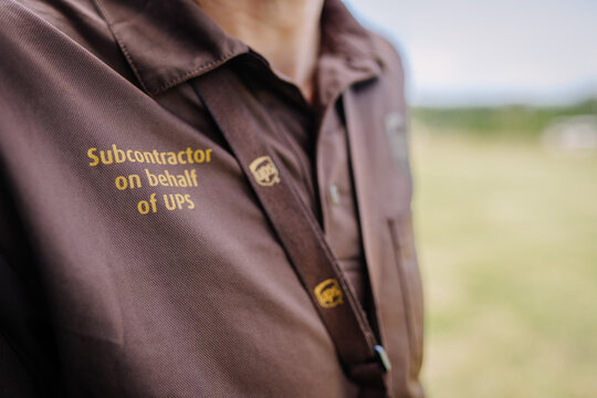 limbazi, Latvia, June 29, 2024 - Close-up of a UPS subcontractor uniform with company branding and a lanyard, outdoors with copy space...