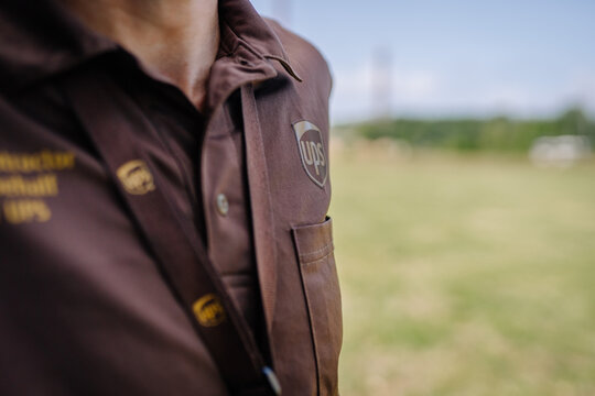 limbazi, Latvia, June 29, 2024 - Close-up of a UPS subcontractor uniform with company branding and lanyard in an outdoor setting, with copy space.