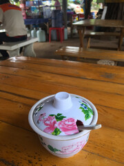 Thai-style pottery on a wooden table in a restaurant.