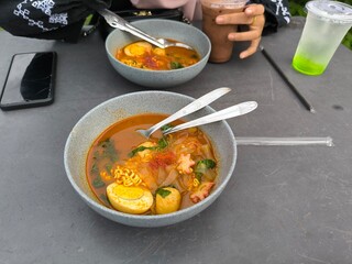 Original seblak topped with egg and fish balls