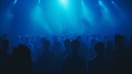 Crowd of people and enthusiastic fans in front of stage at concert, with bright lights and smoke from a smoke machine creating a vibrant atmosphere. Energy and excitement of a live music performance.