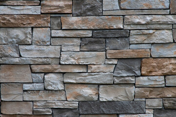 Brown and grey brick stone wall full frame background.