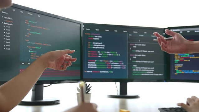 Slow motion back end software developer engineer for computer programming working together on debugging writing computing code, solving complex algorithms display on monitor in office. Burgeoning