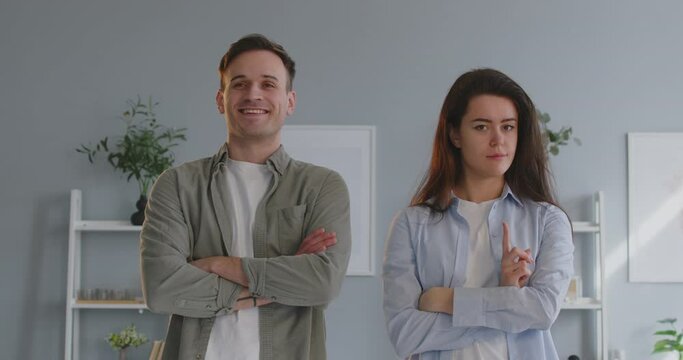 Young married couple having disagreement. Man and woman with different opinions about children's behavior and upbringing, fold arms, nod and shake heads, and make happy and discontent face expressions