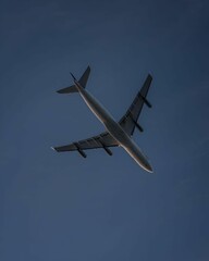 Airbus 340 passenger plane flying against a dark blue sky during twilight.