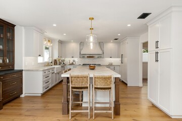 Modern kitchen interior with white cabinets, wooden floor, and central island with wicker chairs