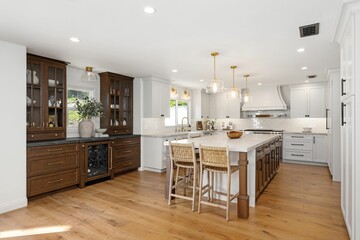 Modern kitchen interior with wooden cabinets, marble countertops, and island.