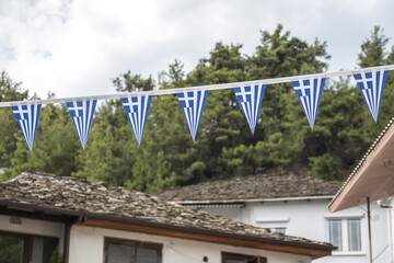 Small triangular Greek flags strung between village houses