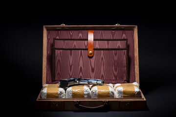 A handgun lies on packages of cocaine
in a briefcase, Handgun and Briefcase of Cocaine