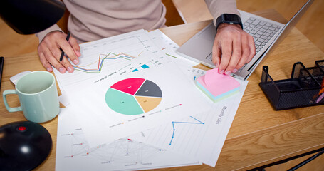 Close up portrait of desk with diagram drawings. Man created workplace at table full of different things. Male analysis data verifying papers with documents on laptop. © ihorvsn