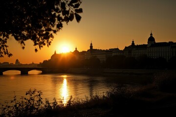 Naklejka premium Breathtaking view of a city skyline against a golden sunset reflected in the river