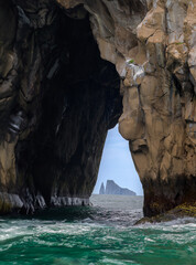 Roca enmarcada en túnel de otra roca en el mar - Kiccker rock (león dormido) enmarcado en túnel de cerro brujo - Isla San Cristóbal - Islas Galápagos - Ecuador