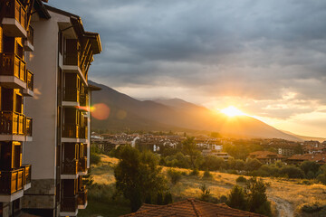 View of Bansko and the surrounding mountains as the setting sun breaks through the clouds, Bulgaria