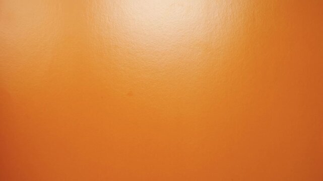Preparation for Halloween. Funny pumpkin rolling on orange screen, stop motion