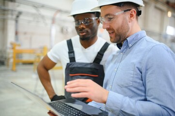 An engineer communicates with a worker on a production line