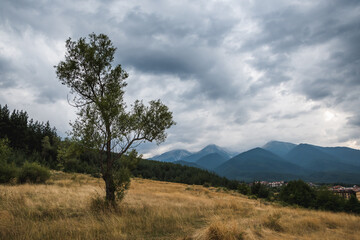 Obraz premium A view of high mountains under a cloudy sky near the town of Bansko in Bulgaria