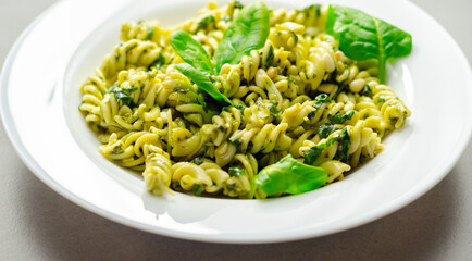 A plate of pasta with spinach on top