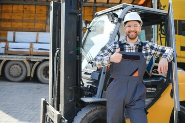 Portrait of professional forklift driver in factory's warehouse