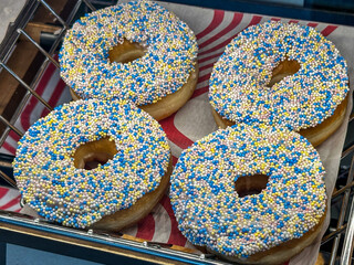 Yeast donuts with tiny blue, yellow, and white sprinkles