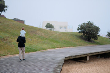 Father and Child Son Daughter Walking on Wooden Pathway by the Beach - Scenic Family Moment