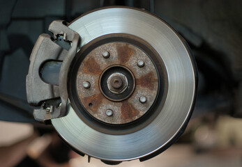 Close-Up of Car Brake Disc and Caliper in Auto Repair Shop Vehicle Maintenance