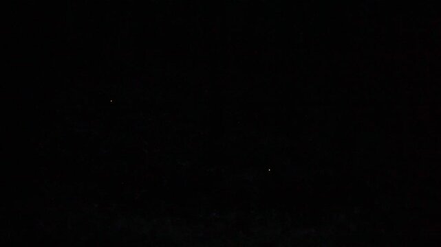 Tottori,Japan - July 2, 2024: Fireflies or Hotaria parvula or Hime botaru flying over Obara river at Fukumaki Hotaru no Kuni, Tottori, Japan, 
