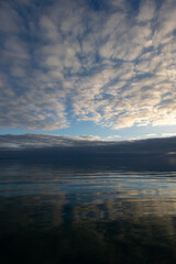 Fototapeta premium Clouds reflecting in a calm sea