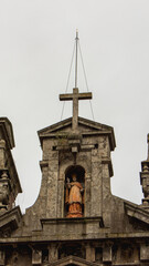 a statue of a saint in an alcove atop Igreja de Santo Ildefonso church in Porto, Portugal