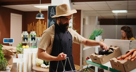 Storekeeper arriving in green living bio supermarket with freshly harvested farm grown food. Vendor restocks local neighborhood grocery shop with pesticides free ethically sourced vegetables