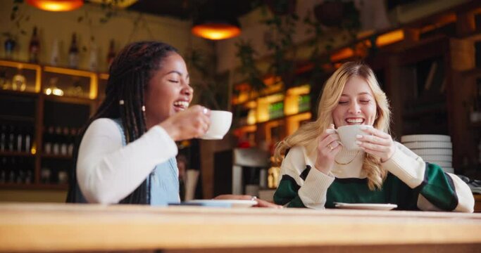 Women, coffee and conversation in cafe as friends with chat, gossip and funny news for social connect. Girls, latte and communication in New York restaurant in morning for reunion, relax and talking