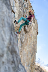 Climber climbs on a rocky wall. Extreme sport climbing.