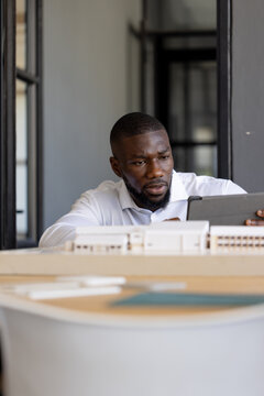 Reviewing building model on tablet, architect working in office
