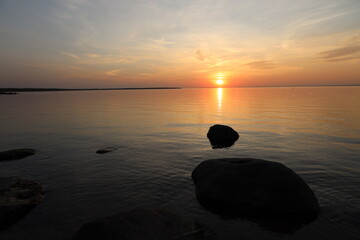 setting sun hovering over tranquil lake