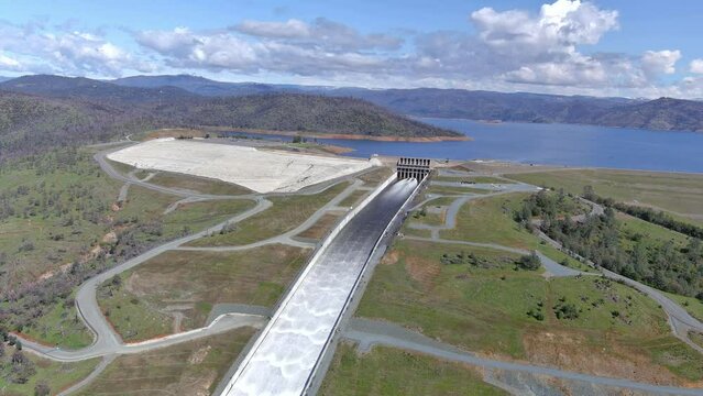 Lake Oroville Dam and spillway with cascading water dumping into the Feather River. 